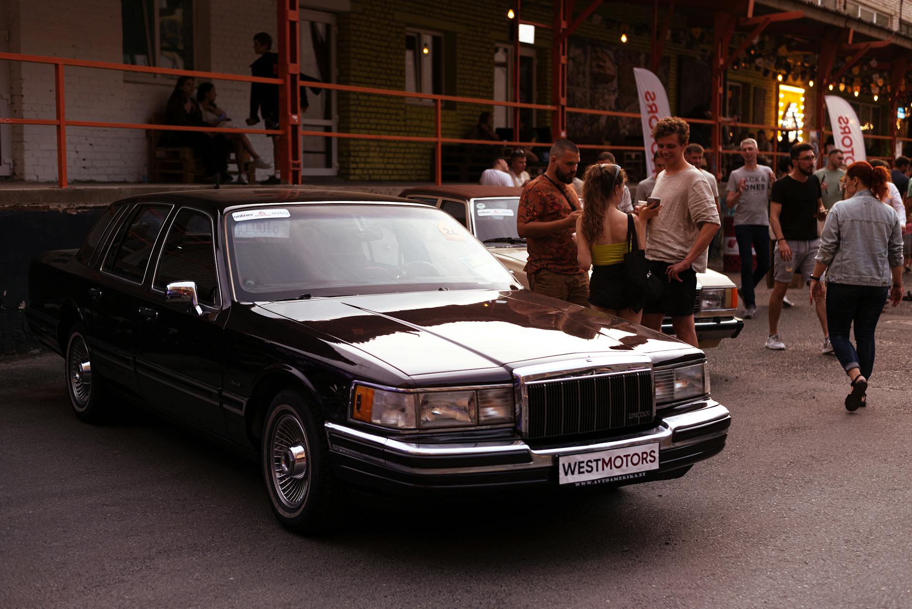 Zabytkowy Lincoln Town Car na zlocie luksusowych aut z ludźmi w tle