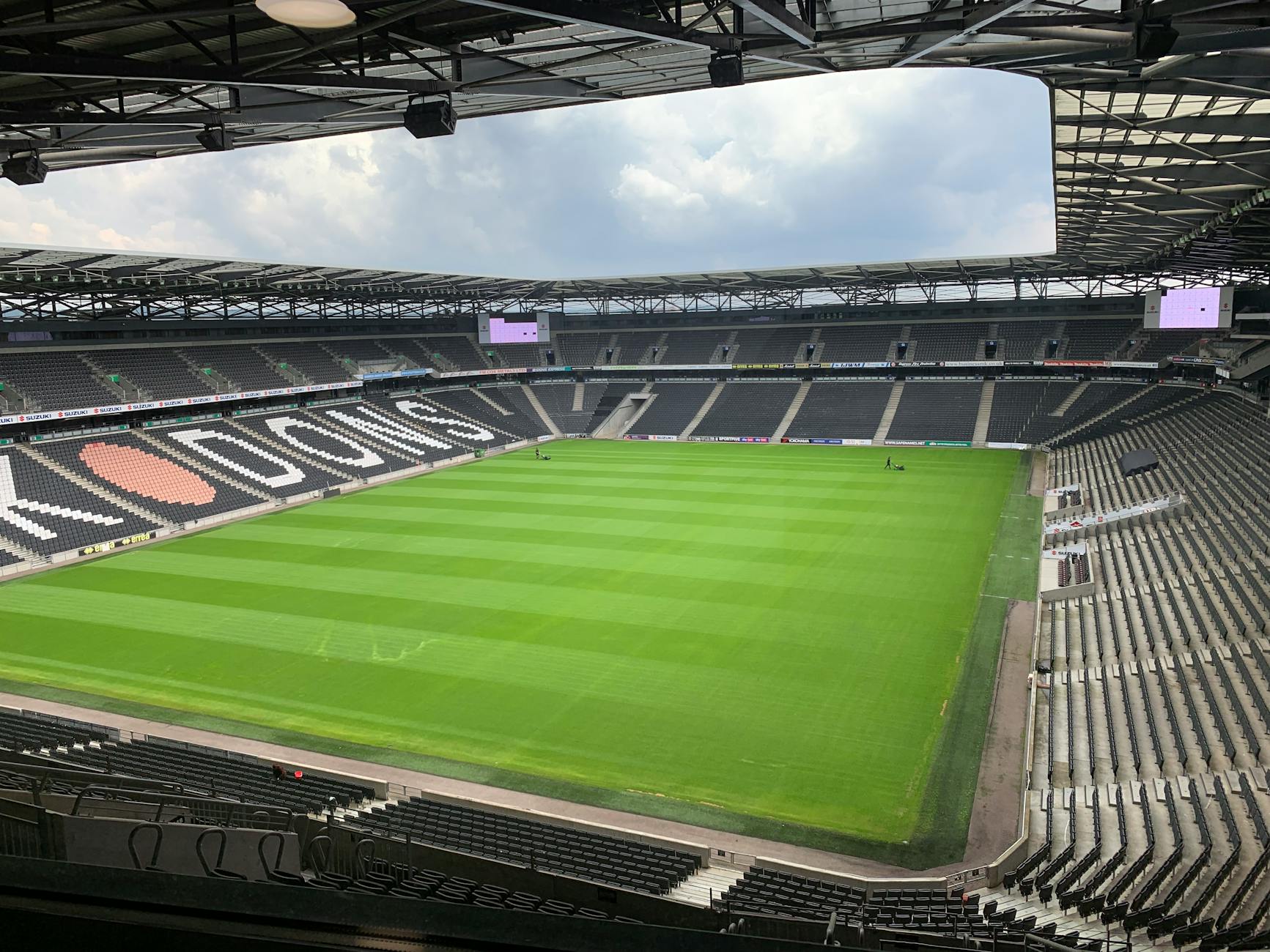 Pusty stadion piłkarski z zieloną murawą w słoneczny dzień