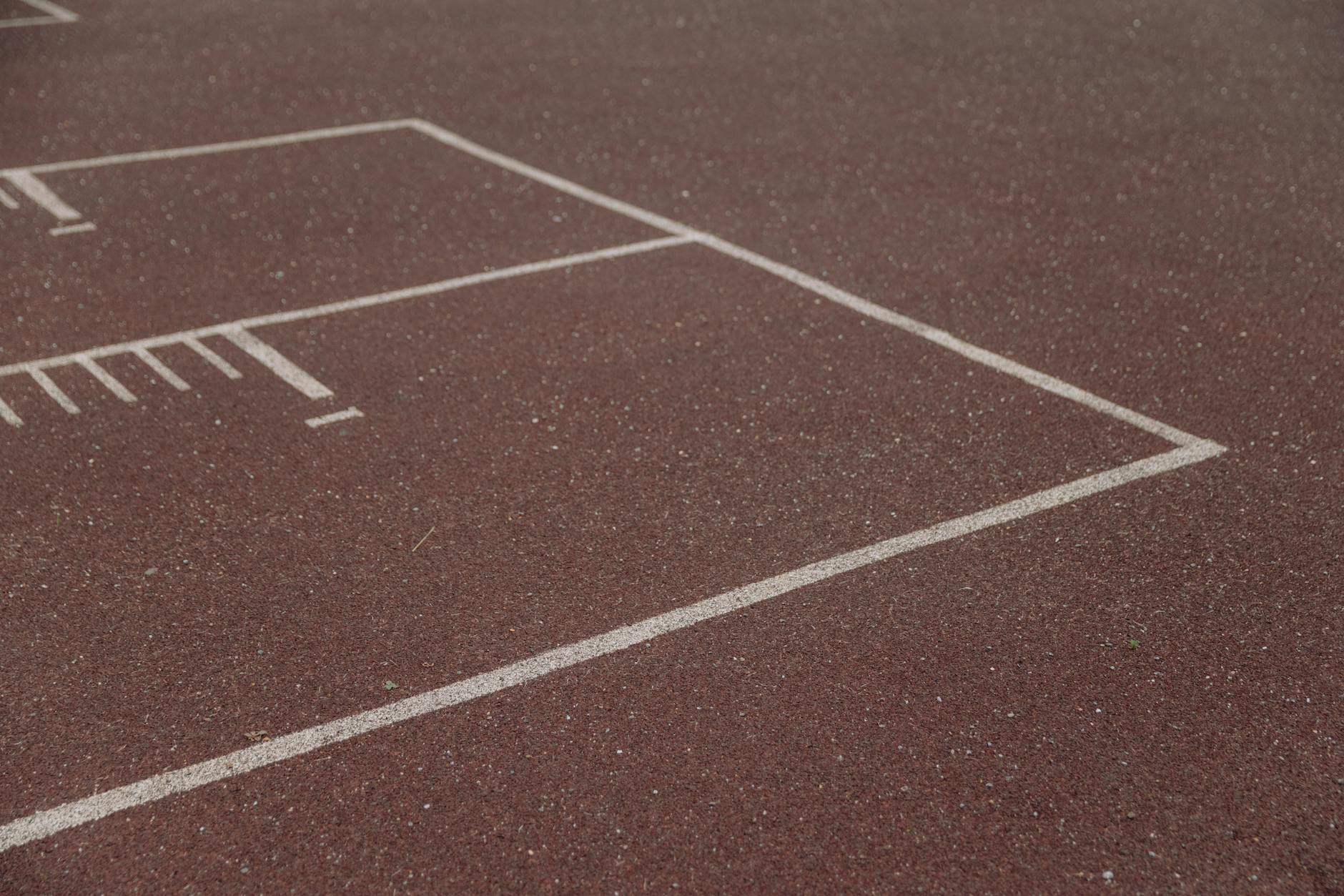 Zbliżenie czerwonej bieżni lekkoatletycznej z białymi liniami