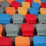 Kolorowe plastikowe krzesełka na trybunach nowoczesnego stadionu