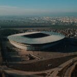 Panoramiczne ujęcie dużego stadionu piłkarskiego otoczonego zabudową