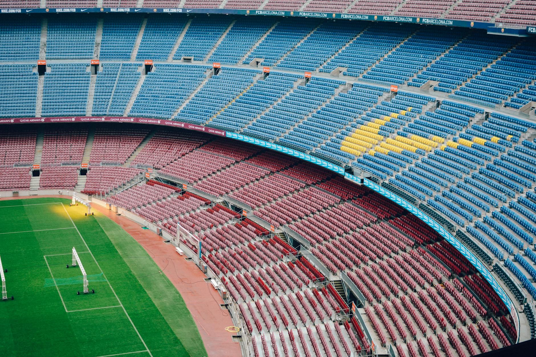 Pusta panorama stadionu Camp Nou z kolorowymi trybunami i murawą