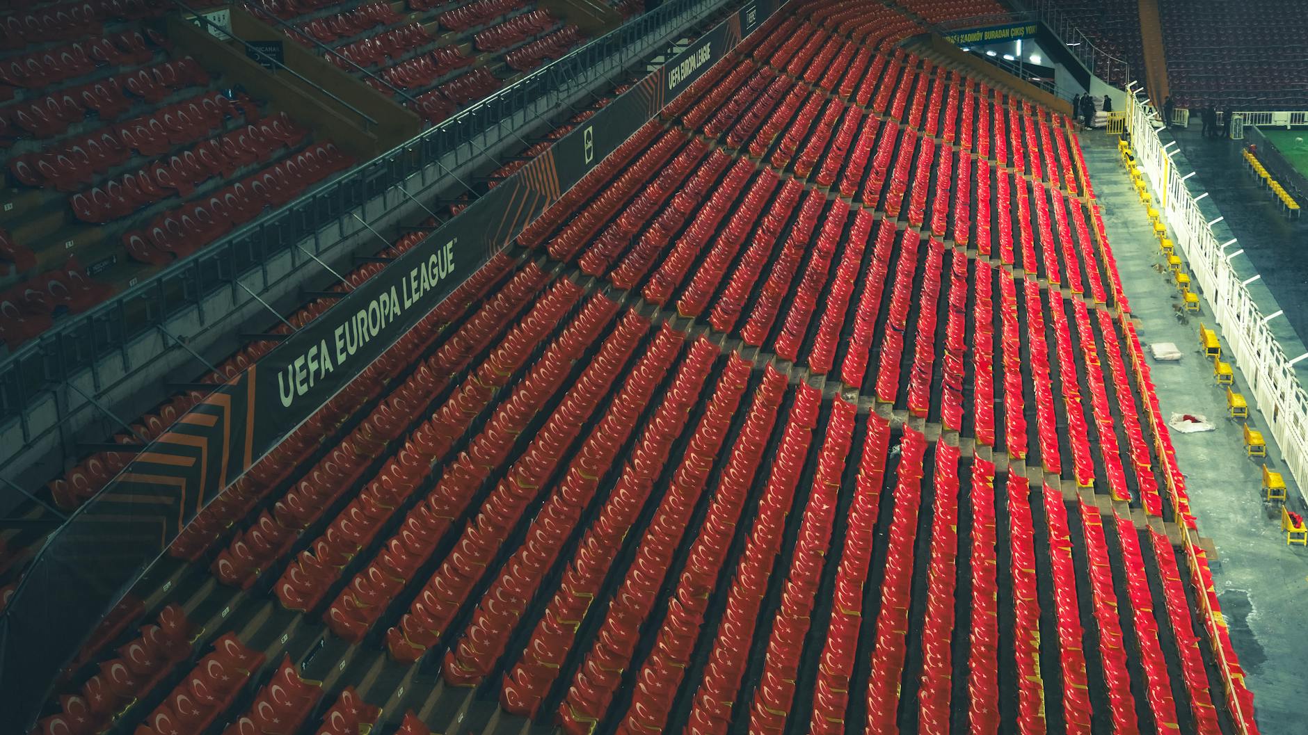 Puste czerwone krzesełka na stadionie Ligi Europy UEFA