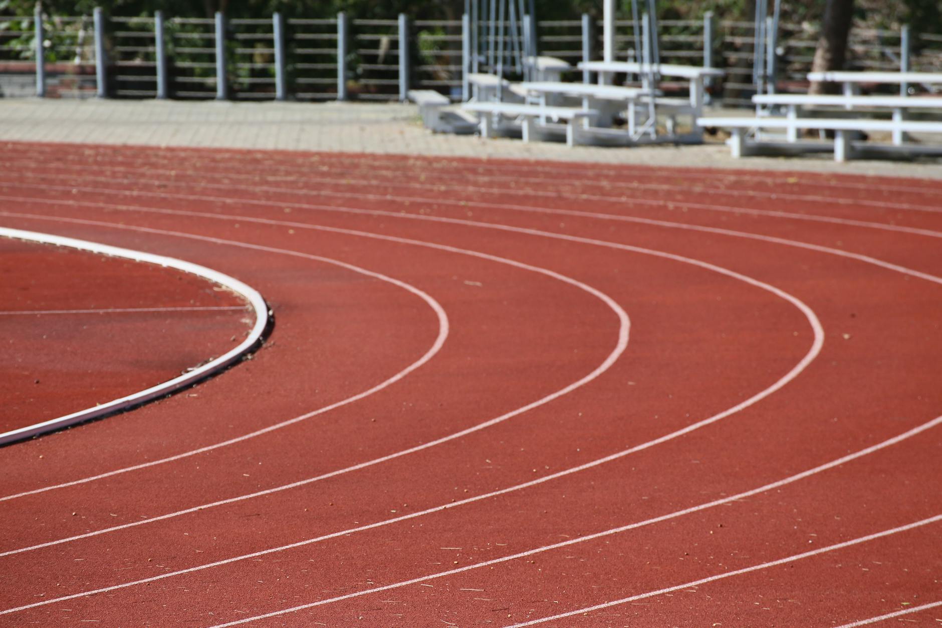 Czerwona bieżnia stadionu lekkoatletycznego z oznaczeniami torów