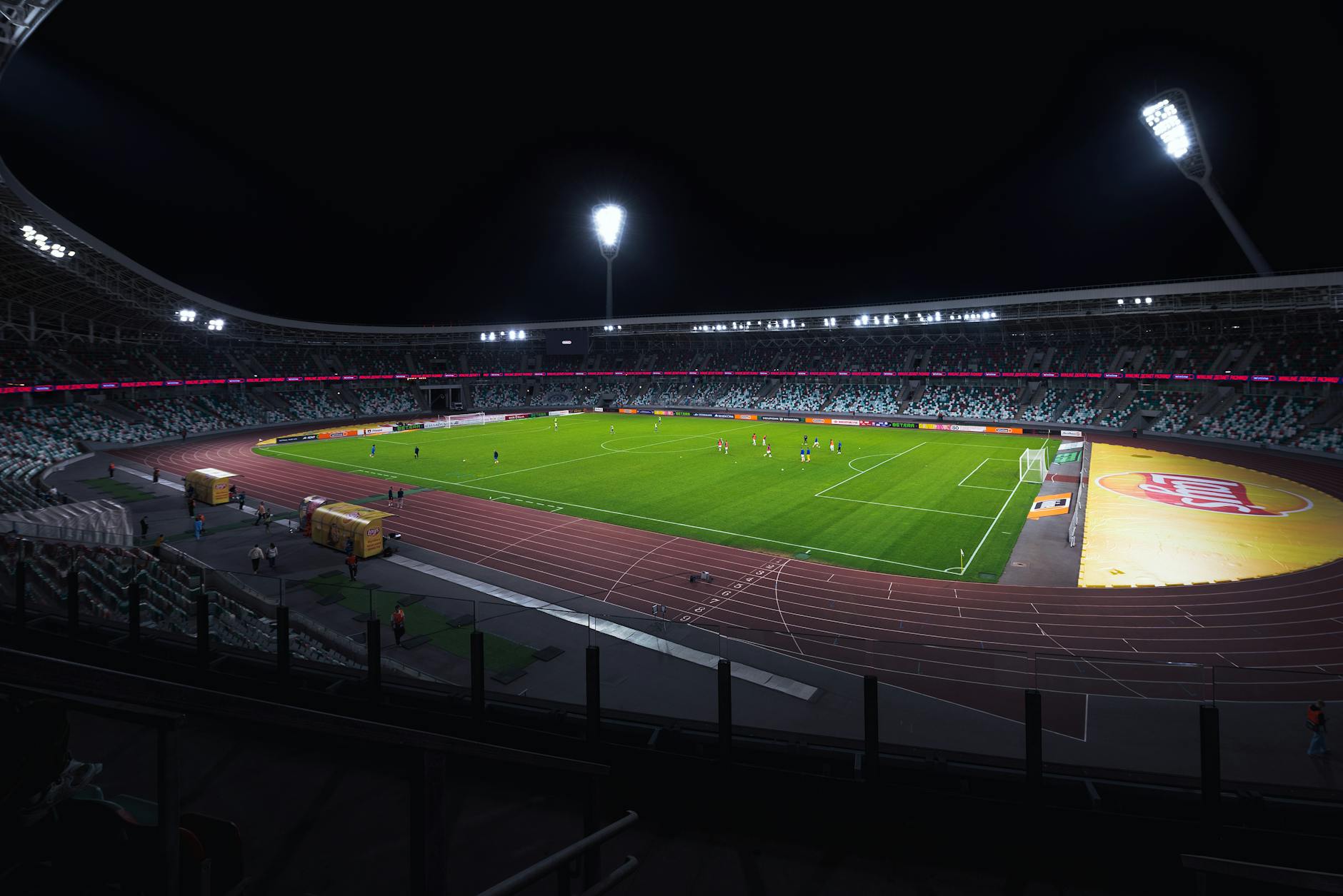 Nocny pusty stadion piłkarski oświetlony reflektorami