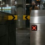 Stalowa bramka biletowa z czerwonym symbolem zakazu wejścia