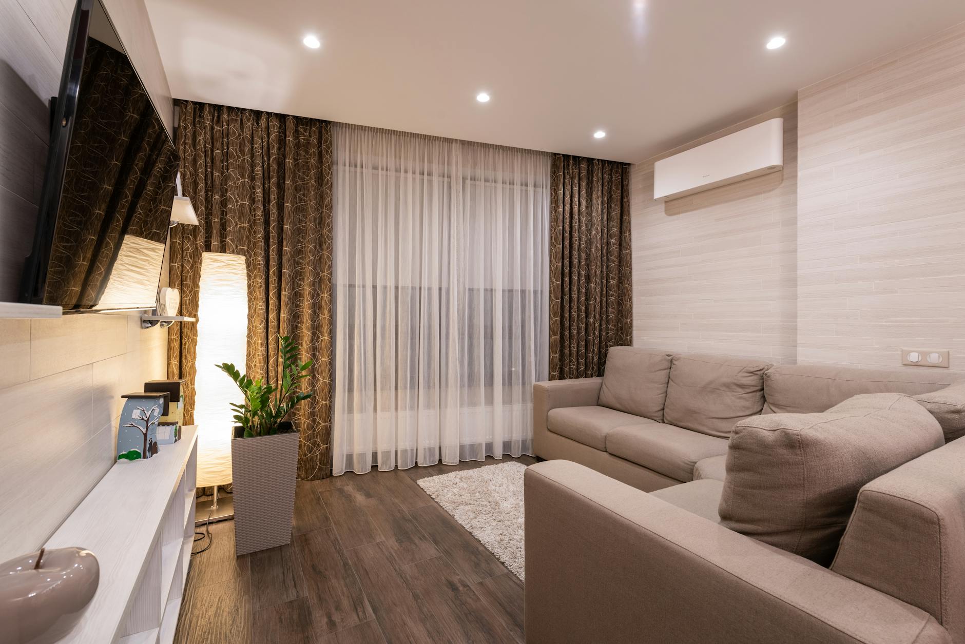 Przytulny salon z drewnianą podłogą, sofą i nastrojowym oświetleniem
