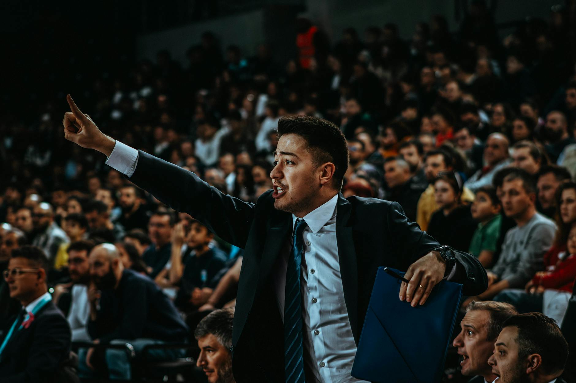 Trener gestykuluje przy linii bocznej podczas meczu NBA w pełnej hali