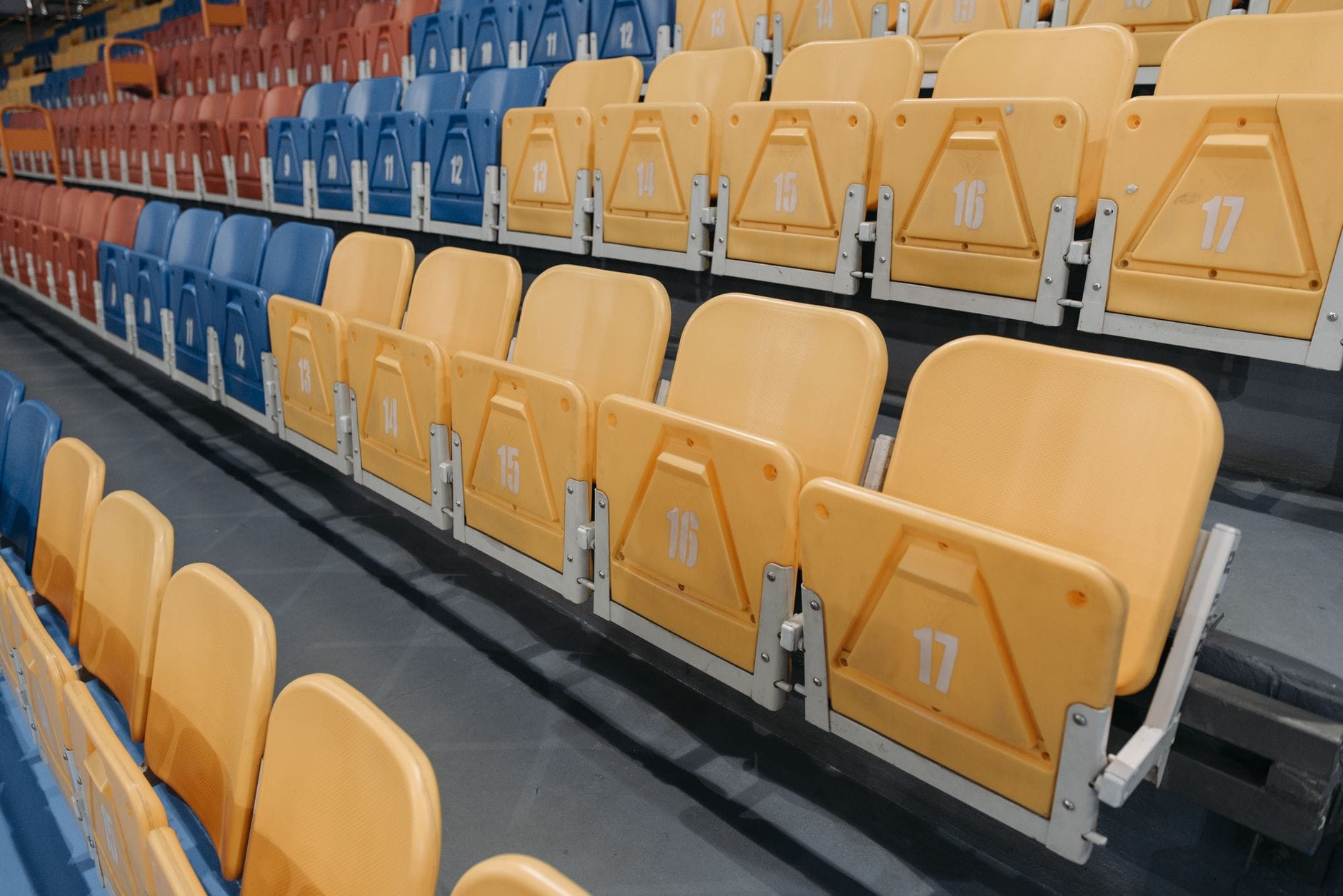 Kolorowe puste krzesełka na trybunach hali sportowej Kolorowe puste krzesełka na trybunach hali sportowej
