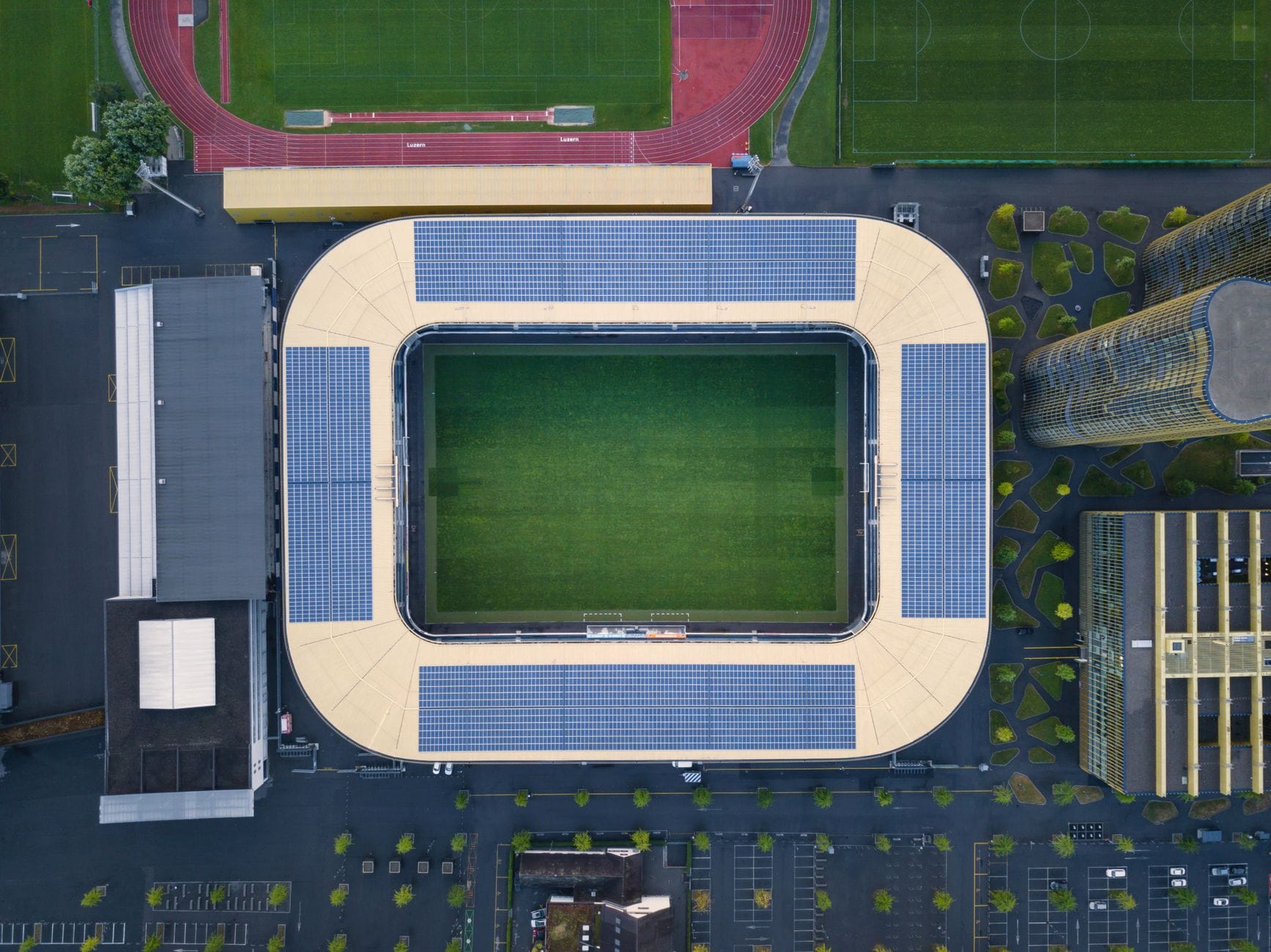 Zielone stadiony: panele PV, retencja i certyfikaty w nowych inwestycjach Nowoczesny stadion z panelami fotowoltaicznymi widziany z drona