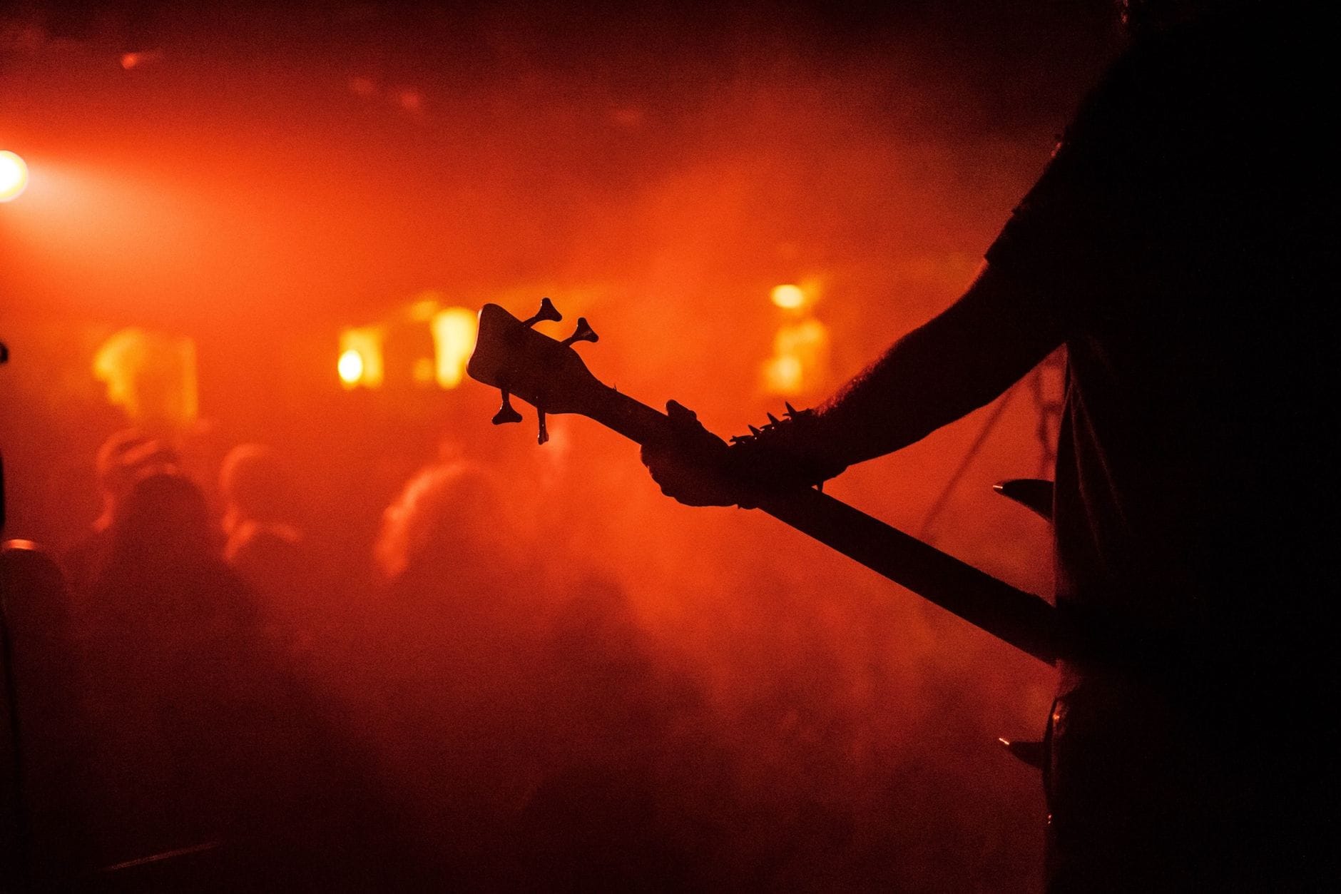 Sylwetka gitarzysty na tle świateł sceny podczas rockowego koncertu